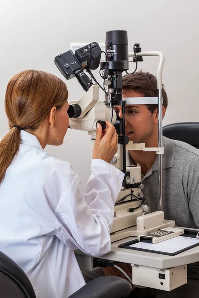 Médico examinando algo para paciente — Fotografia de Stock