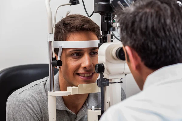 Mann schaut durch das Keratometer — Stockfoto