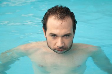 Havuzda dinlenen adam