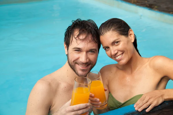 Par i pool dricka saft — Stockfoto
