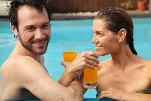 ジュースを飲んでプールでカップル — ストック写真