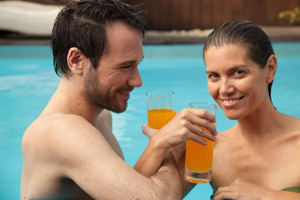 Пара в бассейне питьевой сок — стоковое фото