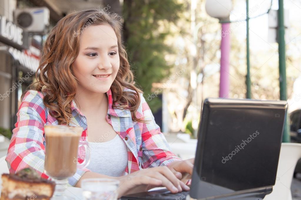 Girl using laptop in cafe