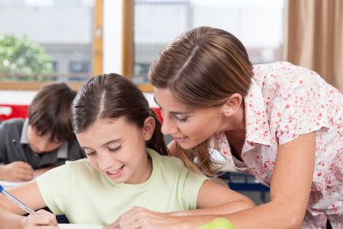 öğretmen bir kıza yardım