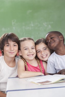 Kameraya bakarak ve gülümseyen öğrenciler