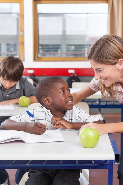 Teacher helping a boy — Stock Photo, Image