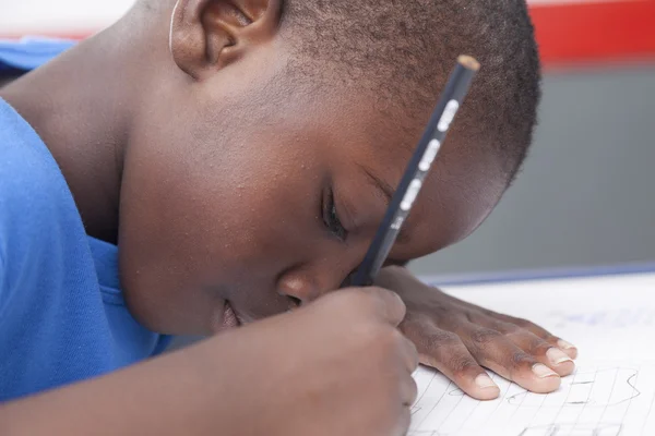 El chico escribiendo en su cuaderno — Foto de Stock