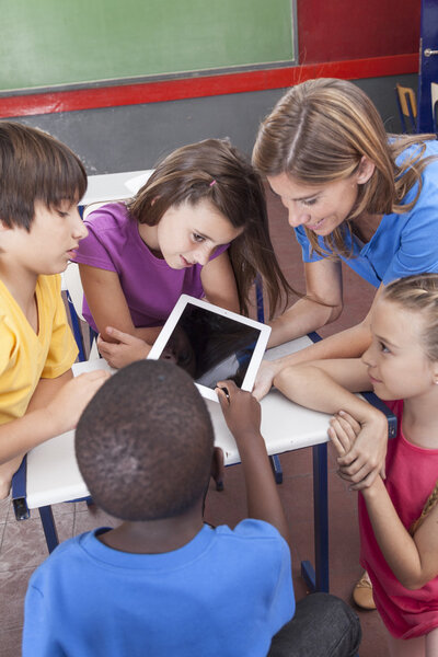 Students and teacher looking at tablet