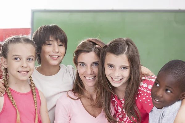 Pupils and teacher looking at camera — Stock Photo, Image