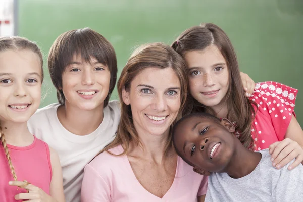 Pupils and teacher looking at camera — Stock Photo, Image