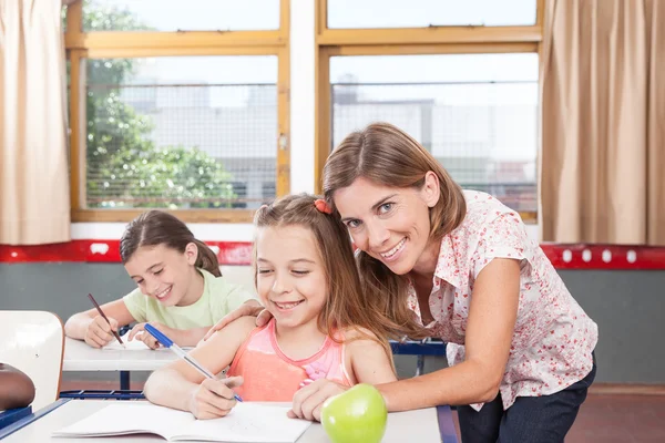 Maestro ayudando a los niños — Foto de Stock