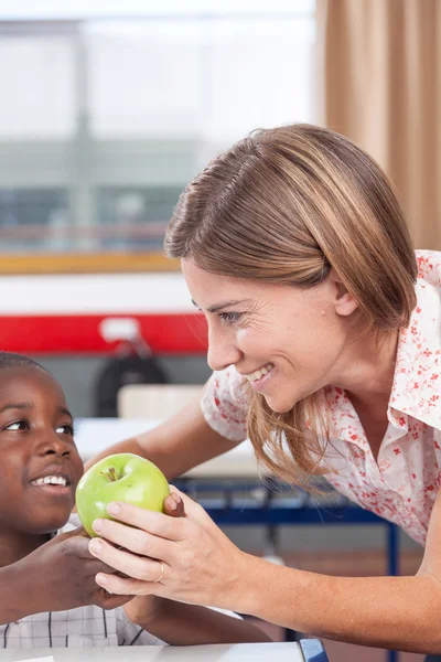 Menino dando a seu professor maçã — Fotografia de Stock