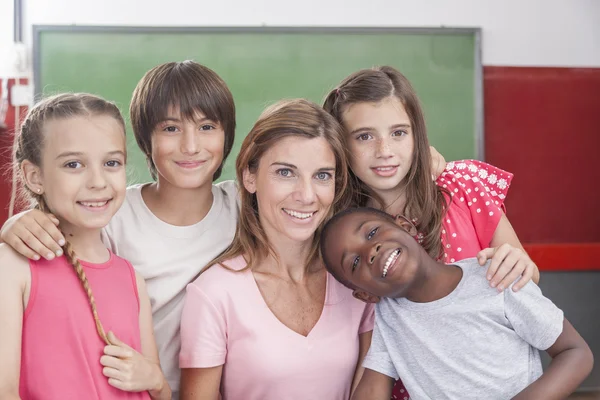 Pupils and teacher looking at camera — Stock Photo, Image