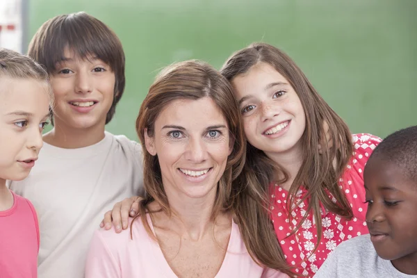 Pupils and teacher looking at camera — Stock Photo, Image