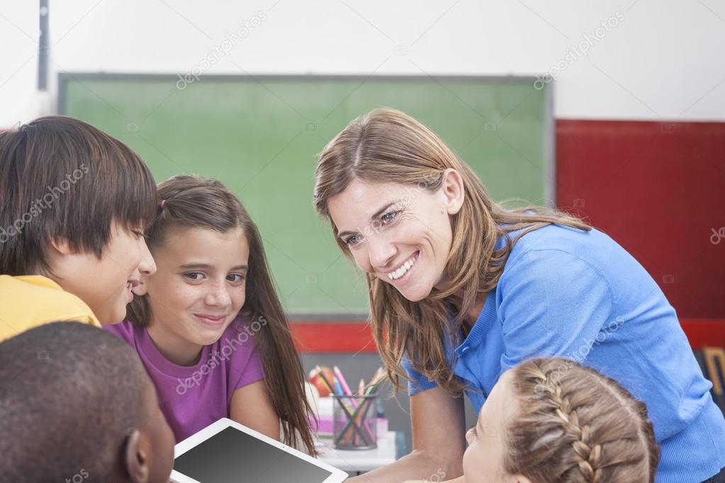 Students and teacher looking at tablet