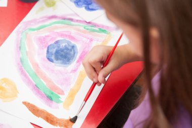 Kız resim çiziyor.