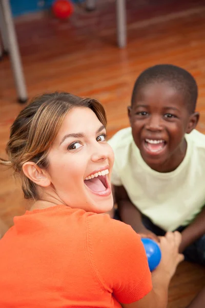 Teacher playing with a little boy — Stock Photo, Image