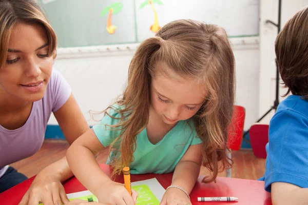 Девочка рисует со своим учителем — стоковое фото