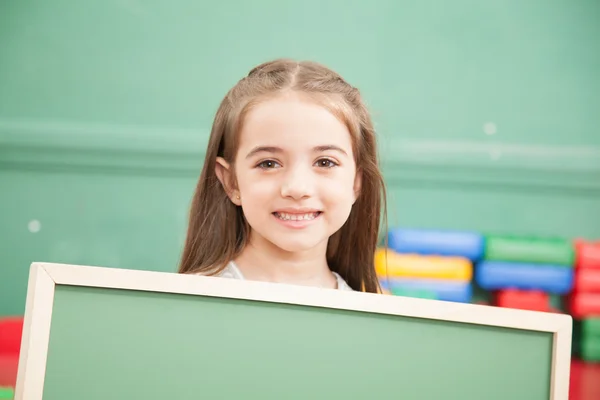 Niña sosteniendo una pizarra — Foto de Stock