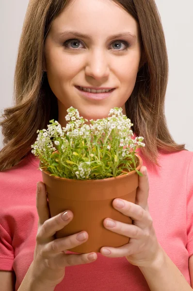 Lächelnde Frau mit einer Pflanze — Stockfoto