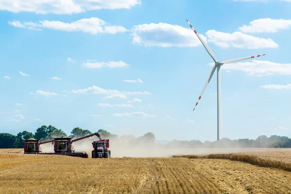 Väderkvarn och kombinerar på fältet — Stockfoto