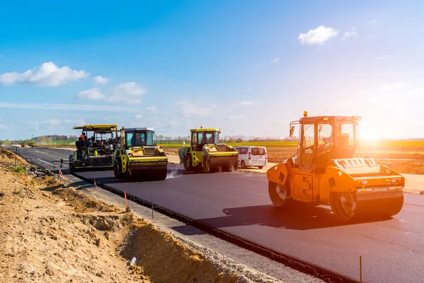 Zonsondergang boven de weg roller werken op de bouwplaats — Stockfoto