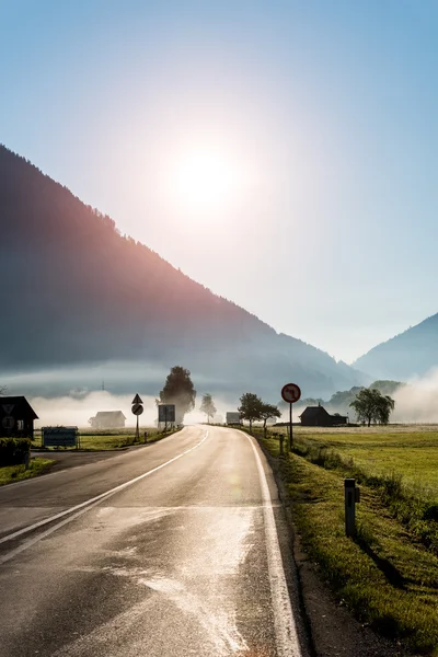 Západ slunce nad mlžné vesnice — Stock fotografie