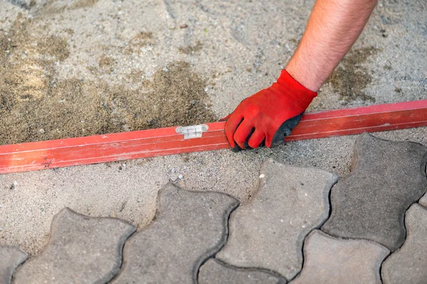 Le travailleur positionne les briques sur le patio — Photo