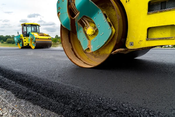 Rodillo de carretera trabajando en el sitio de construcción — Foto de Stock