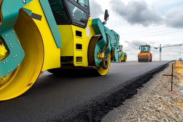 Rodillo de carretera trabajando en el sitio de construcción — Foto de Stock