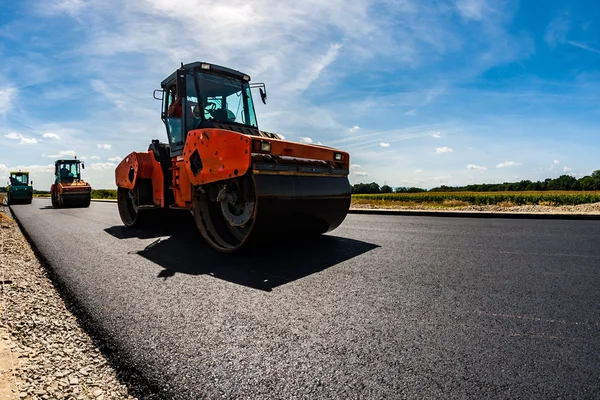 Rodillo de carretera trabajando en el sitio de construcción — Foto de Stock