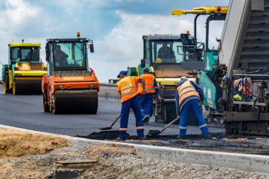 İşçiler ve asphalting makineleri