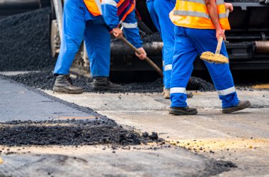 İşçiler ve asphalting makineleri