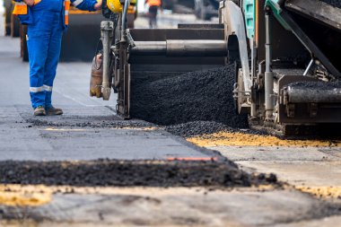 İşçiler ve asphalting makineleri