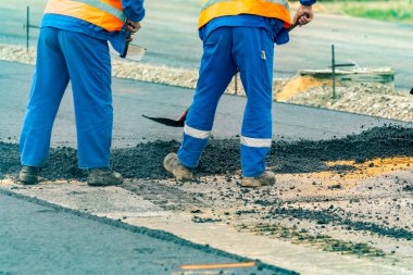 İşçiler ve asphalting makineleri