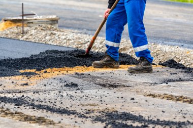 İşçiler ve asphalting makineleri