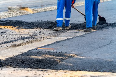 İşçiler ve asphalting makineleri