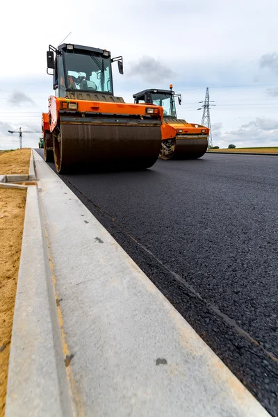 Rodillo de carretera trabajando en el sitio de construcción — Foto de Stock