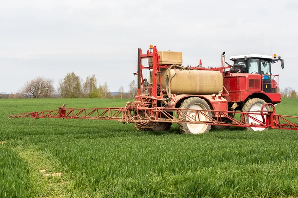 Pulverizando os herbicidas no campo verde — Fotografia de Stock