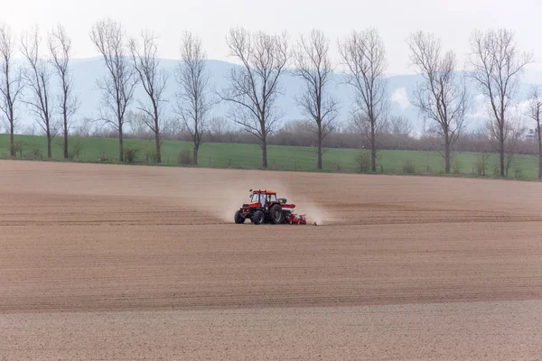 Tractor harrowing the field — Stock Photo, Image