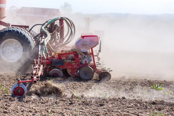 Трактор боронить поле — стокове фото