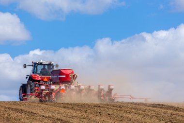 Tractor harrowing the field clipart