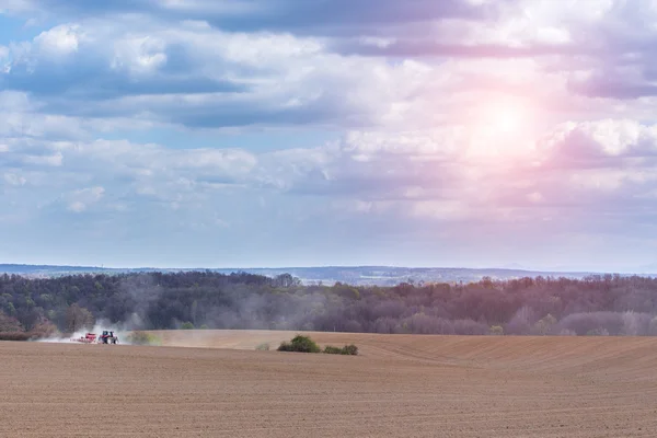 Zonsondergang over de trekker schrijnend het veld — Stockfoto