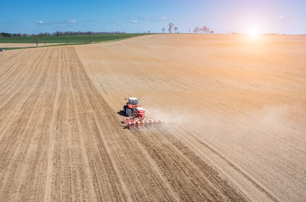 Aerial view of the sunset above the tractor harrowing the field — Stock Photo, Image