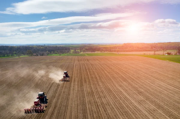 Aerial view of the sunset above the tractor harrowing the field — Stock Photo, Image