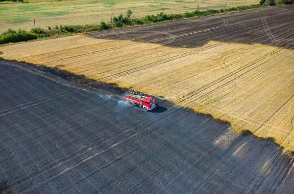 Camión bombero trabajando en el campo en llamas —  Fotos de Stock