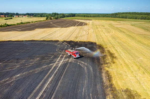 Camion pompiere che lavora sul campo in fiamme — Foto Stock