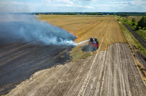 Brandweerman vrachtwagen werken op het veld op brand — Stockfoto