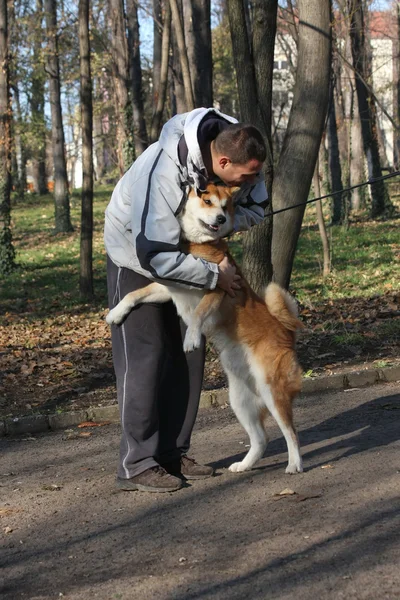 Man and joyful dog in public park — Stock Photo, Image