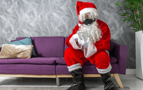 Homem Disfarçado Papai Noel Com Uma Máscara Natal Sentado Sofá — Fotografia de Stock